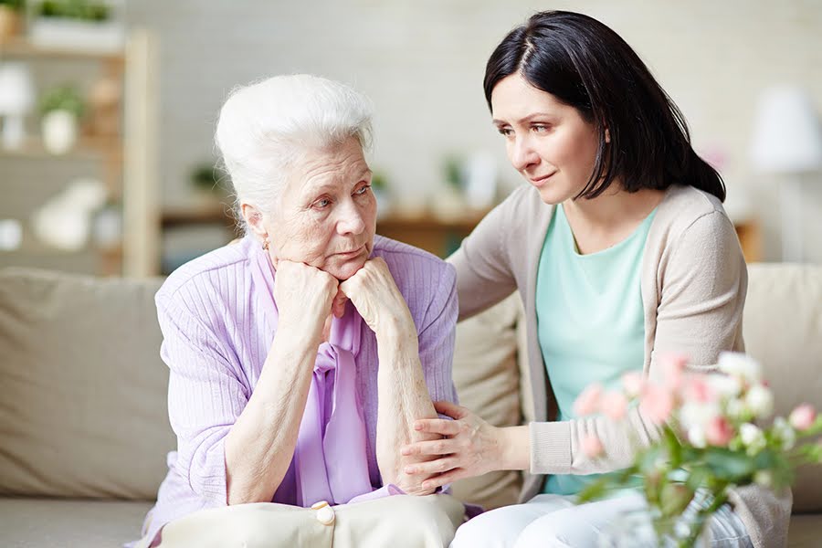 Elderly woman and daughter sharing a quiet moment, highlighting the importance of planning for end-of-life with loved ones.