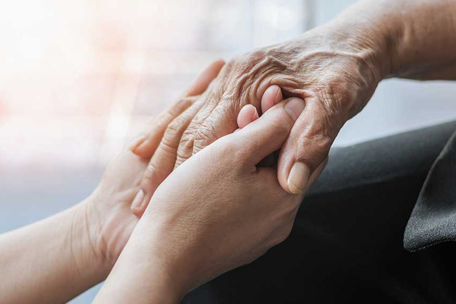 Holding the hand of a senior concept image for palliative care