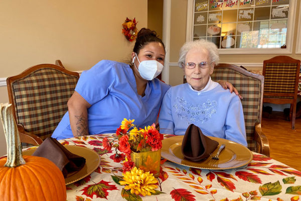 Senior woman and her caregiver at the dining area of the facility.