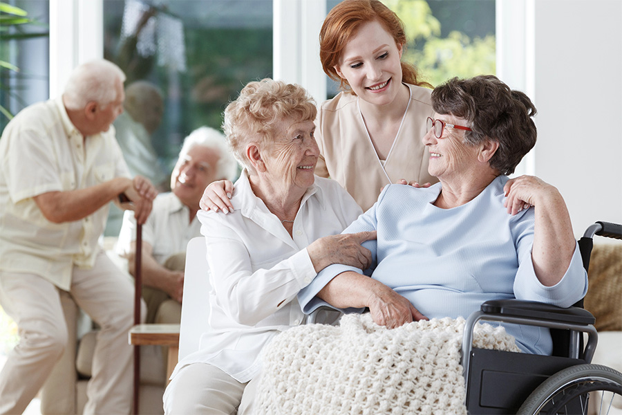 Seniors and a caregiver smile at an assisted living near Chesapeake City, MD, highlighting quality personal care.