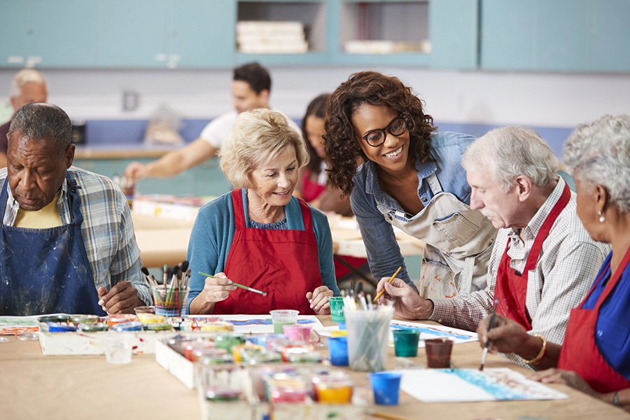 Seniors enjoy an art class at a Maryland assisted living facility with an instructor.