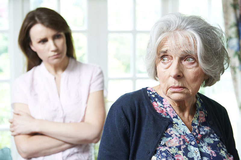 Daughter with her upset mother with dementia.
