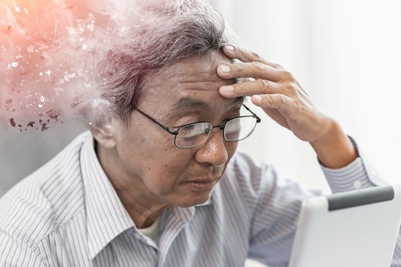 Senior man holding his head concept image for cognitive decline.