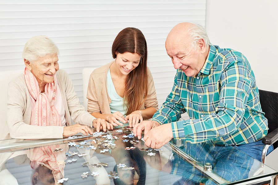 Seniors playing puzzle concept image for memory care activities for seniors.