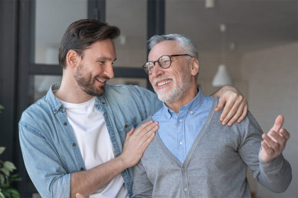 Young adult son having fun with his senior dad.