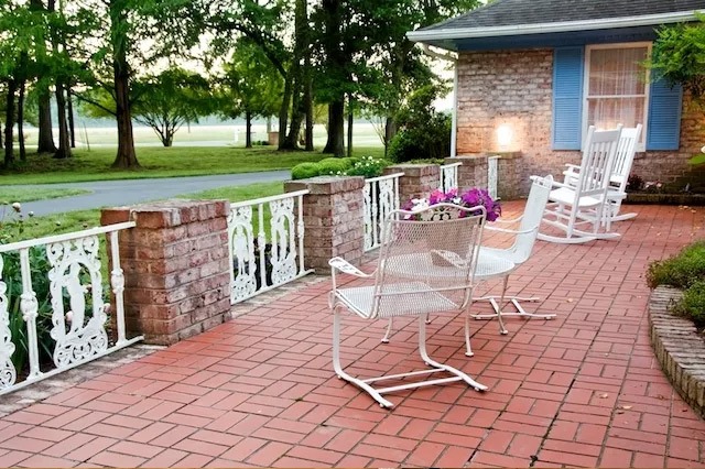 Side view of the picturesque porch at Chesapeake Manor, a prominent assisted living facility in Maryland, with comfortable seating arrangements and lush greenery.