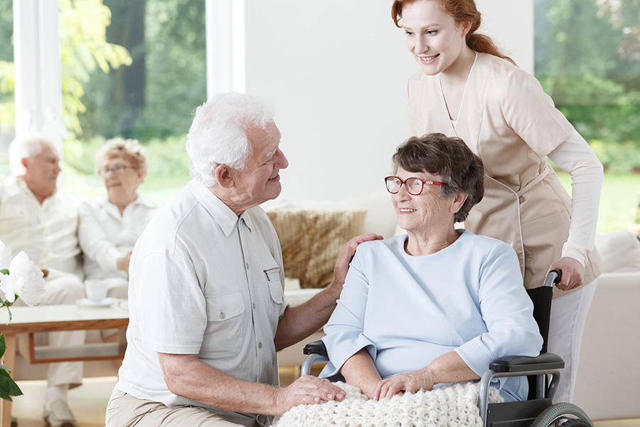 Caregiver and family member supporting a senior resident in a bright assisted living community near Bethany Beach, DE.