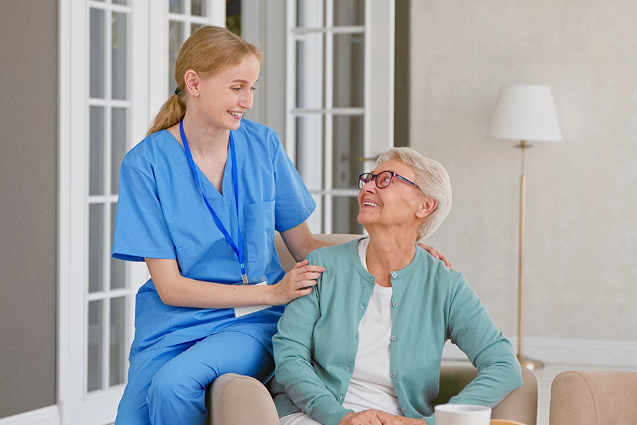Caregiver discussing medication safety plan for seniors with smiling resident in comfortable assisted living setting.