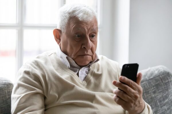 Confused senior man looking at his phone