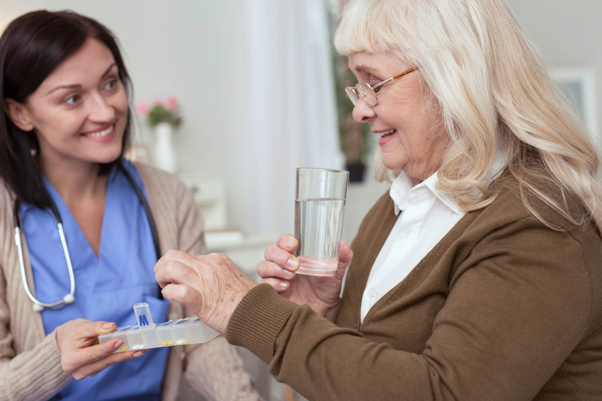 Hero image showing a caregiver helping a senior woman avoid medication mistakes