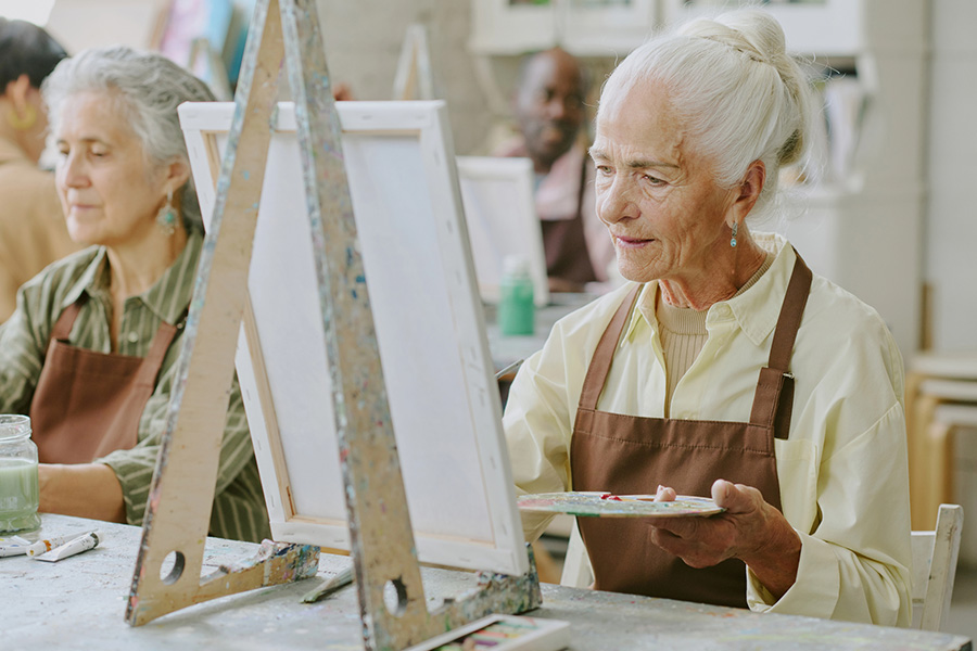 Senior residents enjoy a painting activity in assisted living in Sussex County community art class.