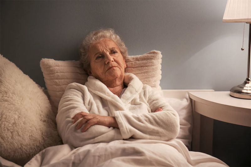 Senior woman having difficulty sleeping because of sundowners syndrome.