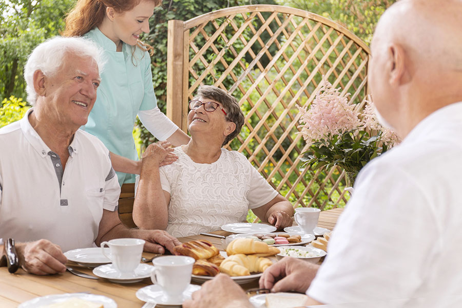 Seniors enjoying an outdoor meal with a caregiver at an assisted living near Bishopville, MD